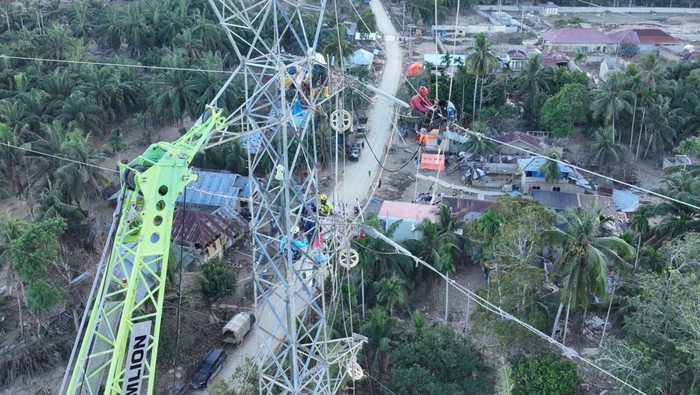 Petugas PLN menangani saluran listrik yang terdampak bencana di Aceh