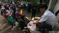 Warga yang berhasil mendapatkan sembako tampak membawa pulang belanjaan mereka dengan wajah puas.