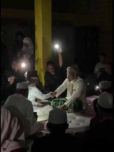 Listrik padam saat akad nikah di Kelantan tak halangi prosesi. Dibantu cahaya ponsel dan lilin dari tamu, suasana berubah romantis bak candle light dinner.