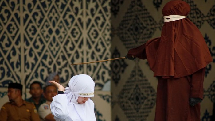 Algojo mengeksekusi cambuk terpidana pelanggar peraturan daerah (qanun) tentang hukum syariat Islam di Panggung Taman Bustanussalatin, Banda Aceh, Aceh, Selasa (7/4/2026). Mahkamah Syariat Kota Banda Aceh menjatuhkan hukuman cambuk sebanyak delapan hingga 100 kali kepada enam terpidana yang terbukti melanggar Qanun Aceh Nomor 12 Tahun 2025 tentang perubahan atas Qanun Aceh Nomor 6 Tahun 2014 tentang Hukum Jinayat dalam perkara jarimah zina, bermesraan antara laki-laki dan perempuan yang bukan suami istri (ikhtilath), dan judi (maisir). ANTARA FOTO/Akramul Muslim/nym.