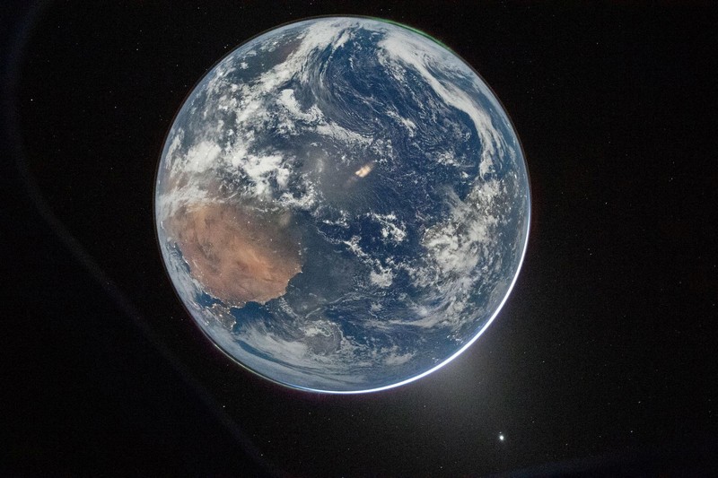 NASA astronaut and Artemis II mission specialist Christina Koch peers out of one of the Orion spacecraft's main cabin windows, looking back at Earth, as the crew travels towards the Moon April 2, 2026.  NASA/Handout via REUTERS. THIS IMAGE HAS BEEN SUPPLIED BY A THIRD PARTY. REFILE - CORRECTING YEAR FROM 