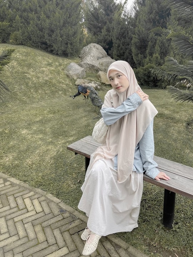 Gaya santai di luar ruangan ini memadukan outer denim berwarna biru muda dengan rok lebar berwarna krem yang feminin. Hijab instan berwarna senada dengan rok menciptakan kontras yang menarik namun tetap terlihat kalem. Foto: Dok. Instagram @denisarani.
