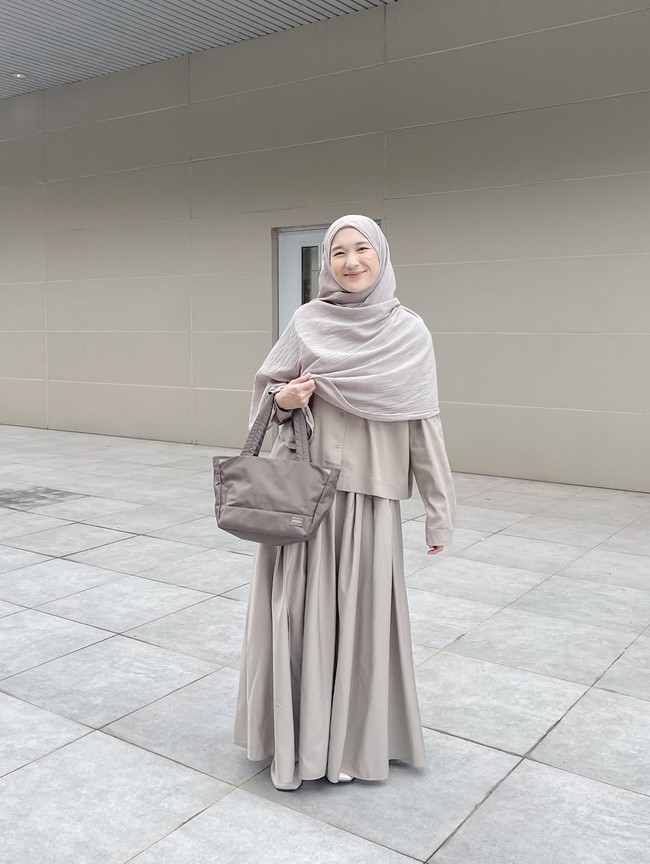 Selanjutnya, padu padan yang terdiri dari kemeja berpotongan pendek dan rok lebar ini cocok bagi kamu yang ingin tampil dinamis. Khimar panjang yang menutupi bahu dan dada tetap menjadi poin utama yang menjaga kesantunan gaya tersebut. Foto: Dok. Instagram @denisarani.