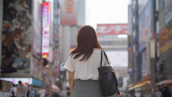 Woman walking in Akihabara, famous tourist spot in Japan