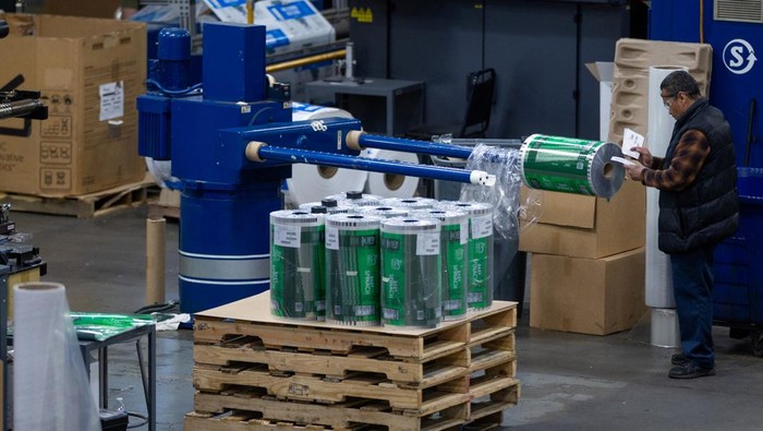 An employee operates a machine next to rolls of plastic to produce grocery bags at Emerald Packaging in Union City, California, U.S., April 6, 2026. As the U.S.-Israel conflict with Iran continues, Kevin Kelly, chief executive of Emerald Packaging, believes prices are expected to rise for the plastic resin that Emerald Packaging turns into produce bags for grocery stores, with a two‑step jump over a few weeks—from 45 to 55 and then to 85 cents per pound—setting up likely disputes with customers and possible force majeure cancellations of contracts it can no longer afford to honor. REUTERS/Carlos Barria