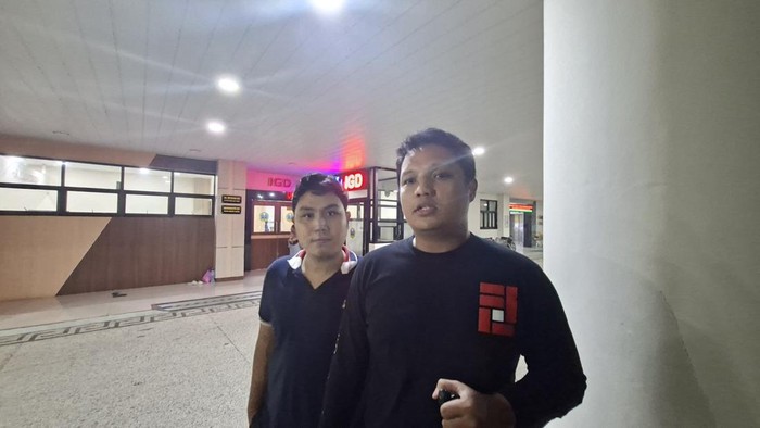 Purnama didampingi rekannya saat berada di RS Bhayangkara Surabaya