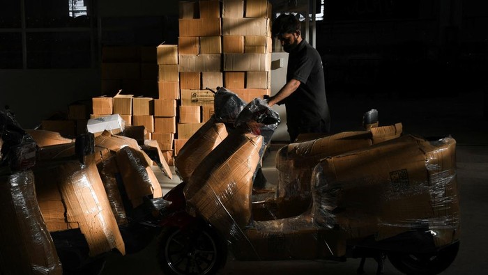 Nasir Husain 40, a sales officer, speaks with a customer at his electric motorcycle showroom in Hyderabad, Pakistan April 1, 2026. REUTERS/Yasir Rajput