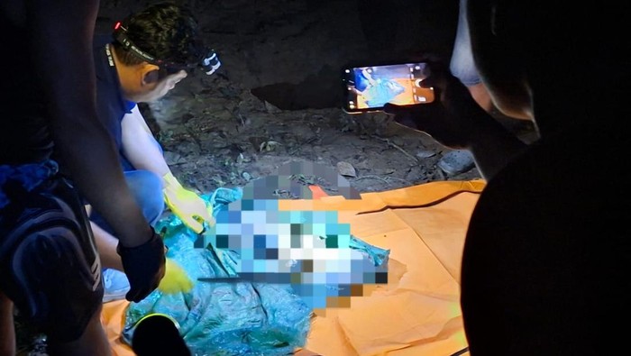 Polisi mengevakuasi potongan tubuh korban yang telah dikubur