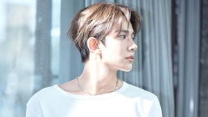 Dalam foto, EVAN tampil simpel mengenakan T-shirt putih dengan lengan yang digulung. Style ini dipadukan dengan celana jeans dan aksesori minimalis kalung silver. (Foto: dok. Belift Lab/HYBE)