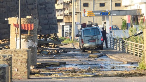 A man stands next to a vehicle near the last remaining bridge linking southern Lebanon to the rest of the country after it was struck on Wednesday by Israel, in Qasmiyeh, Lebanon, April 9, 2026. Picture taken with a mobile phone. REUTERS/Stringer