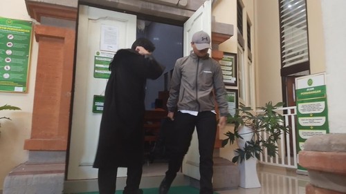 Mahasiswa inisial IMS, Terdakwa pengancaman terhadap mantan kekasih (pakai jaket dan topi), seusai menjalani sidang di PN Denpasar, Kamis (9/3/2026). (Wibhi Leksono/detikBali)
