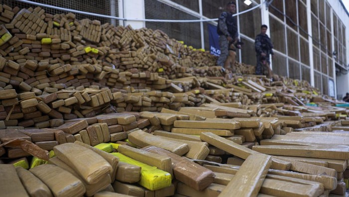 Military police officers with sniffer dogs guard about 48 tonnes of marijuana seized in the Mare favela complex, police said, in Rio de Janeiro, Brazil, April 8, 2026. REUTERS/Ricardo Moraes