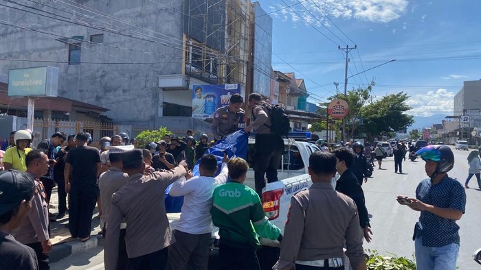 Polisi mengevakuasi jenazah pengendara motor wanita yang terlindas mobil di Palu.