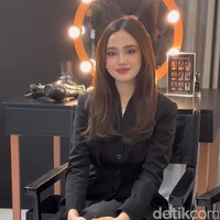 Syifa memilih busana rapi dan sopan dengan atasan lengan panjang dan celana panjang. Ia melengkapi penampilannya dengan strap heels senada. Foto: Wolipop/Vina Oktiani