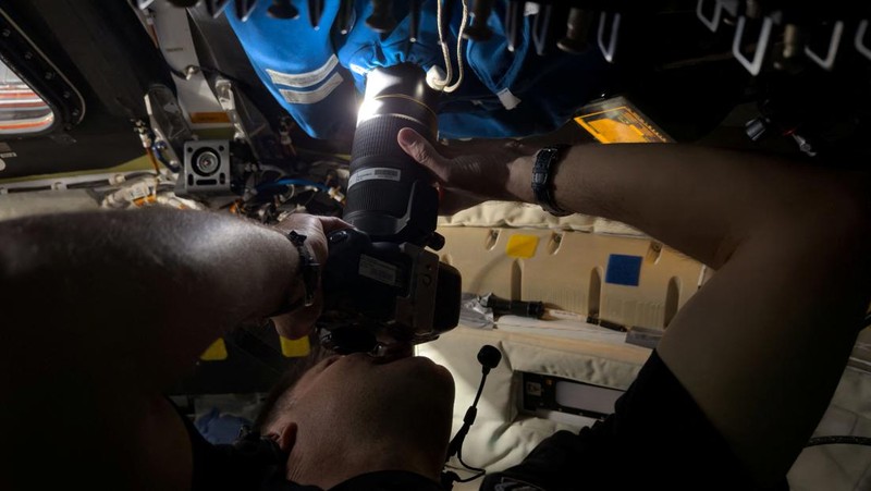 Canadian Space Agency (CSA) astronaut and Artemis II Mission Specialist Jeremy Hansen takes photographs using a camera shroud covering window 2 of the Orion spacecraft during the Artemis II crew’s flyby of the Moon April 6, 2026.      NASA/Handout via REUTERS THIS IMAGE HAS BEEN SUPPLIED BY A THIRD PARTY