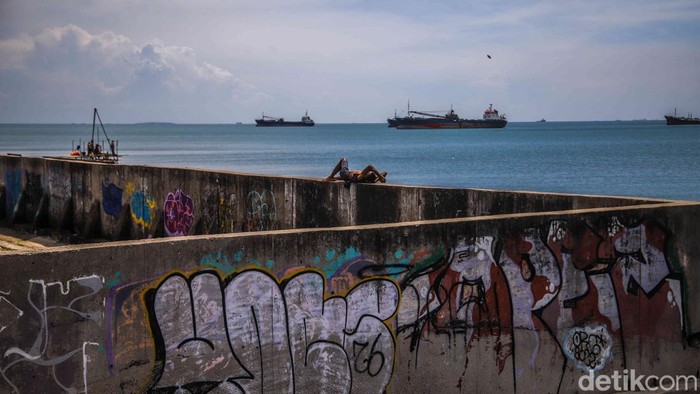 Sejumlah warga beraktivitas di kawasan Tanggul Muara Baru, Jakarta Utara, Jumat (10/4/2026). Kondisi tanggul yang seharusnya melindungi dari air laut justru tampak memprihatinkan.