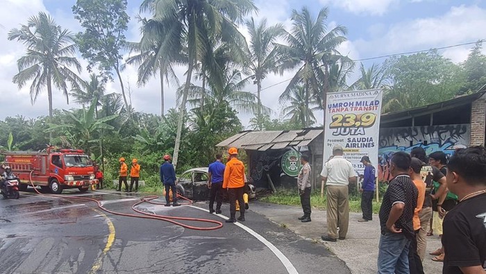 Petugas berusaha memadamkan api yang membakar VW di Cangkringan