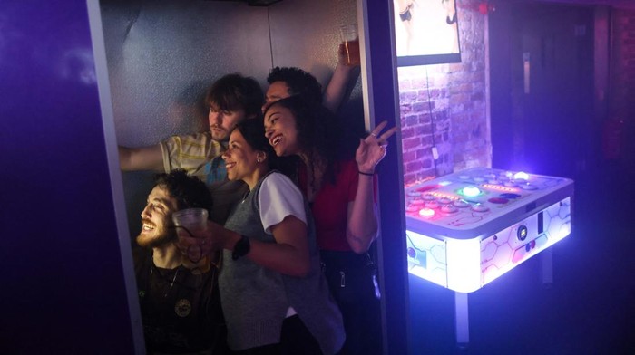 People gather at the smoking area outside The Carpet Shop nightclub in Peckham in London, Britain, November 15, 2025. REUTERS/Jack Taylor     TPX IMAGES OF THE DAY