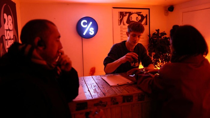 People gather at the smoking area outside The Carpet Shop nightclub in Peckham in London, Britain, November 15, 2025. REUTERS/Jack Taylor     TPX IMAGES OF THE DAY
