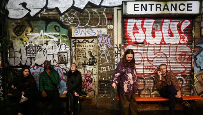 People gather at the smoking area outside The Carpet Shop nightclub in Peckham in London, Britain, November 15, 2025. REUTERS/Jack Taylor     TPX IMAGES OF THE DAY