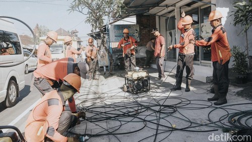 Pemkab Badung menertibkan kabel menjuntai di ruas Jalan Raya Darmasaba, Kecamatan Abiansemal, Badung, Bali, Jumat (10/4/2026). (Foto: Agus Eka/detikBali)
