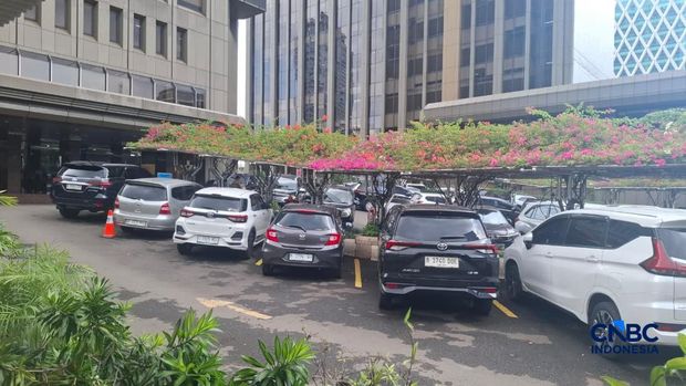 Sejumlah kendaraan masih memenuhi area parkir di kantor Kementerian Perumahan dan Kawasan Permukiman di Jakarta, Jumat (10/4/2026), seiring penerapan kebijakan work from home (WFH) bagi ASN dan imbauan serupa bagi sektor swasta. (CNBC Indonesia/Ferry Sandi)