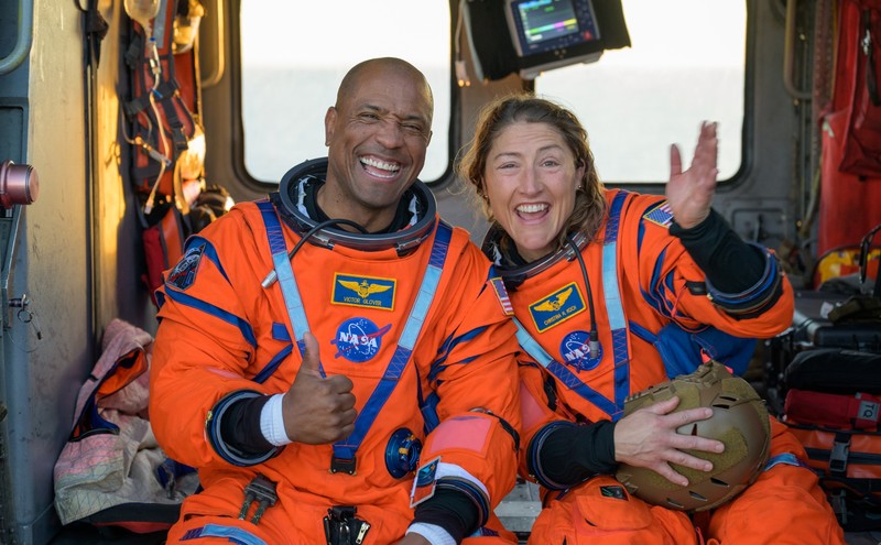 NASA astronaut Victor Glover, Artemis II pilot, left, and NASA astronaut Christina Koch, Artemis II mission specialist are seen sitting on a Navy MH-60 Seahawk from Helicopter Sea Combat Squadron (HSC) 23 on the flight deck of USS John P. Murtha after they and fellow crewmates CSA (Canadian Space Agency) astronaut Jeremy Hansen, Artemis II mission specialist, and NASA astronaut Reid Wiseman, Artemis II commander, were extracted from their Orion spacecraft after splashdown, Friday, April 10, 2026, in the Pacific Ocean off the coast of California. NASA’s Artemis II mission took the quartet on a nearly 10-day journey around the Moon and back to Earth. Following a splashdown at 5:07 p.m. PDT (8:07 p.m. EDT), NASA, U.S. Navy, and U.S. Air Force teams are working to bring the Orion spacecraft aboard the recovery ship.