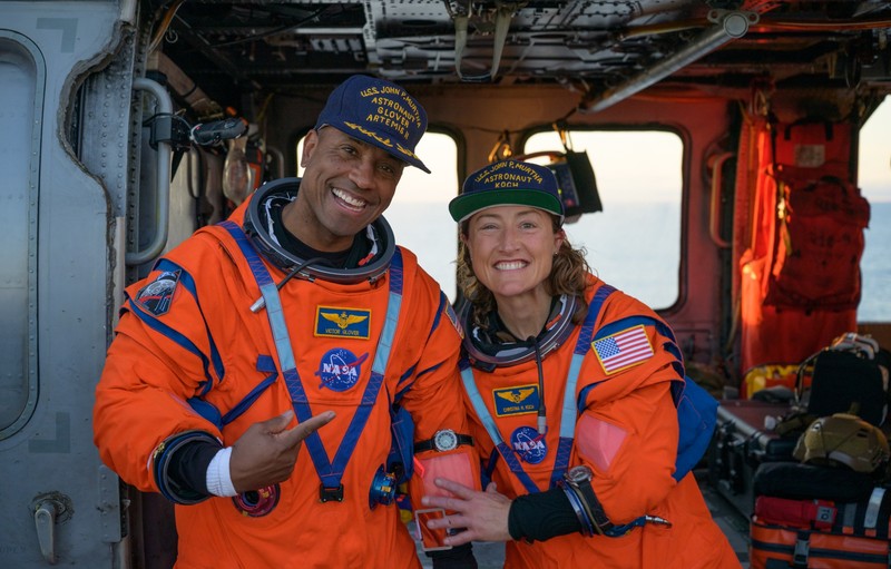 NASA astronaut Victor Glover, Artemis II pilot, left, and NASA astronaut Christina Koch, Artemis II mission specialist are seen sitting on a Navy MH-60 Seahawk from Helicopter Sea Combat Squadron (HSC) 23 on the flight deck of USS John P. Murtha after they and fellow crewmates CSA (Canadian Space Agency) astronaut Jeremy Hansen, Artemis II mission specialist, and NASA astronaut Reid Wiseman, Artemis II commander, were extracted from their Orion spacecraft after splashdown, Friday, April 10, 2026, in the Pacific Ocean off the coast of California. NASA’s Artemis II mission took the quartet on a nearly 10-day journey around the Moon and back to Earth. Following a splashdown at 5:07 p.m. PDT (8:07 p.m. EDT), NASA, U.S. Navy, and U.S. Air Force teams are working to bring the Orion spacecraft aboard the recovery ship.
