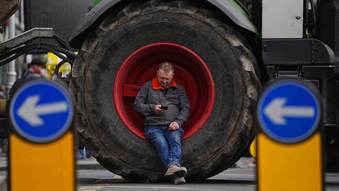 People with their luggage walk past the heavy traffic on Dublin's M50 Northbound, due to vehicles taking part on the third day of a National Fuel Protest against rising fuel prices. Hauliers and agricultural contractors staged a series of slow-moving convoys on motorways as well as blockades of fuel depots and major routes across the country on Tuesday and Wednesday. Picture date: Thursday April 9, 2026. (Photo by Brian Lawless/PA Images via Getty Images)