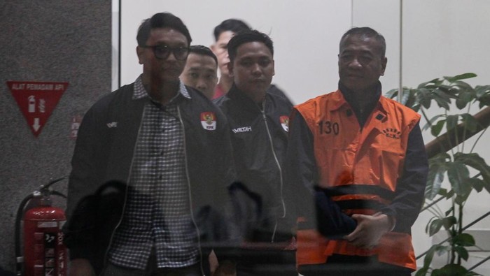 Bupati Tulungagung Gatut Sunu Wibowo (kanan) mengenakan rompi tahanan usai menjalani pemeriksaan setelah terjaring Operasi Tangkap Tangan (OTT) di Gedung Merah Putih KPK, Jakarta, Minggu (12/4/2026) dini hari. KPK menetapkan status tersangka dan mena
