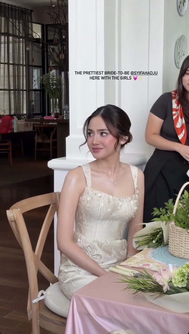 Rambutnya ditata dengan model low bun. Ada beberapa helai rambut yang dibiarkan jatuh di sisi wajah, memberi kesan natural dan lembut. Foto: Instagram/@syifahadju