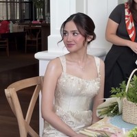 Rambutnya ditata dengan model low bun. Ada beberapa helai rambut yang dibiarkan jatuh di sisi wajah, memberi kesan natural dan lembut. Foto: Instagram/@syifahadju