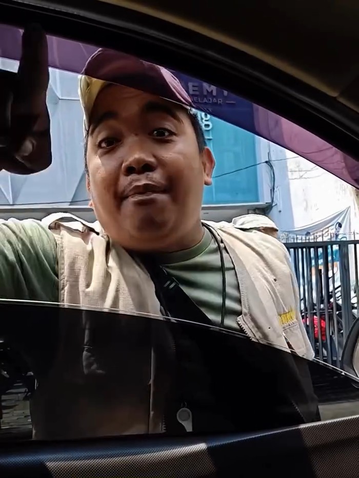 Seorang driver mobil terlibat cekcok dengan juru parkir di kawasan Kusuma Bangsa, Surabaya, saat hendak menurunkan pesanan katering.