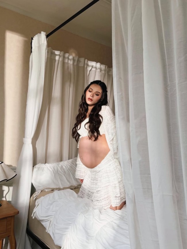 Meski tengah hamil besar, Alyssa tetap terlihat cantik mempesona. Ia tampil kenakan setelan crop top dengan bahan lace warna putih. Potongannya longgar dengan lengan panjang yang melebar, memberi kesan anggun. Bagian perut dibiarkan terbuka, menonjolkan bare baby bump yang terlihat mulus tanpa stretchmarks. Foto: Instagram/@alyssadaguise