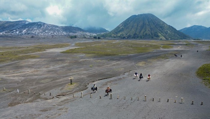 Foto udara warga menunggang kuda melintasi jalur kaldera tengger di kawasan Taman Nasional Bromo Tengger Semeru (TNBTS), Kabupaten Probolinggo.