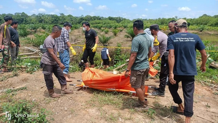 Polisi saat mengevakuasi mayat pria di kanal rawa Desa Kebon IX, Muaro Jambi