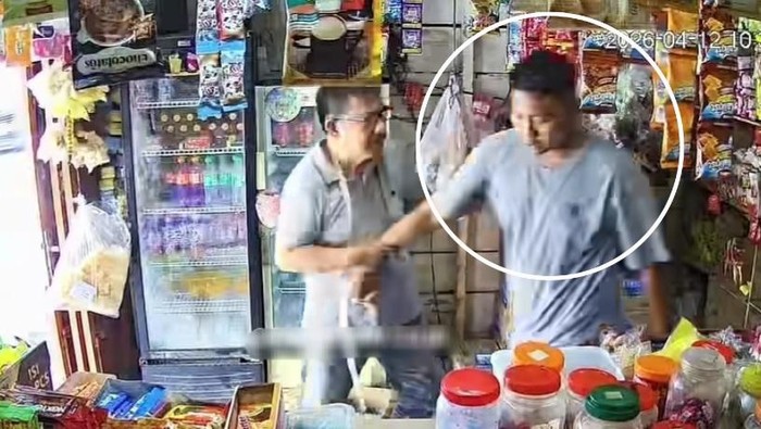 Pria berbaju abu (kanan) yang diduga hendak membakar warung warga. (Foto: dok.medsos)