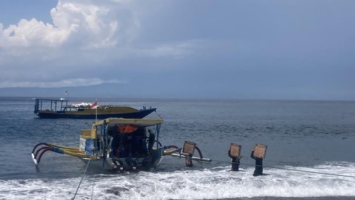 Sejumlah pekerja tengah mengangkut bahan bangunan ke atas perahu di pesisir kawasan Pelabuhan Tribuana, Desa Kusamba, Kecamatan Dawan, Klungkung. (Fatih Kudus Jaelani/detikBali)