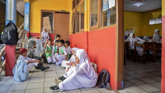 Sejumlah murid berjalan di dekat pagar yang dipasang oleh pihak ahli waris di SDN Bunisari, Ngamprah, Kabupaten Bandung Barat, Jawa Barat, Senin (13/4/2026).  Penutupan akses pada bangunan belakang sekolah oleh pihak ahli waris lahan tersebut menyebabkan delapan ruang kelas, satu ruang guru, dan satu perpustakaan tidak dapat digunakan untuk kegiatan belajar mengajar (KBM) serta menimbulkan keresahan di lingkungan sekolah sehingga pihak sekolah menerapkan sistem kelas bergantian bagi seluruh murid guna proses pembelajaran tetap berjalan. ANTARA FOTO/Abdan Syakura/wsj.