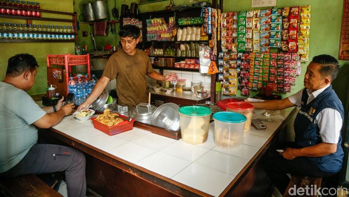 Penjual memberikan jajanan kepada pelanggan di Jakarta, Senin (13/4/2026).