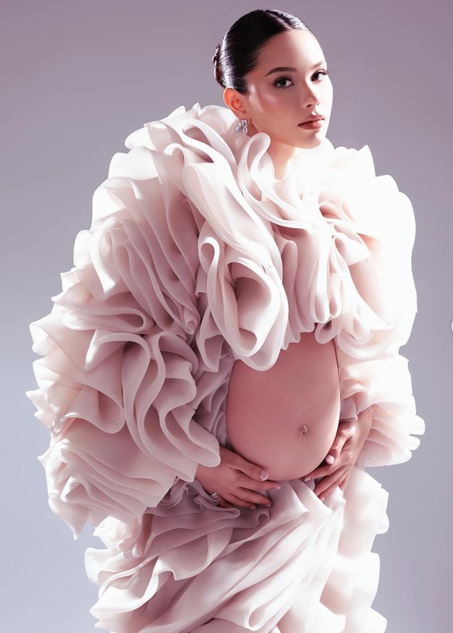 Kali ini Alyssa memilih mewarnai pemotretan maternitynya dengan tampilan yang dramatis. Berbalut gaun ruffle unik rancangan by GAIL, istri Al Ghazali tampil memukau. Foto: Instagram/@alyssadaguise