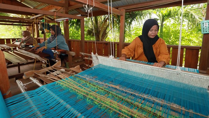 Ira Mutiara (33), pemilik rumah produksi Mutiara Songket, memperlihatkan kain songket khas Aceh di Aceh Besar, Aceh, Selasa (14/4/2026). Rumah produksi tersebut mampu memproduksi kain songket khas Aceh sebanyak 10 helai per bulan dengan beragam motif seperti Pintu Aceh, Bunga Lawang, dan Bunga Jeumpa yang dipasarkan ke berbagai daerah seperti Sumatera Utara, Sumatera Barat, Sulawesi, dan Jakarta dengan harga jual berkisar Rp800 ribu-Rp3 juta per helai serta turut dipamerkan pada ajang fesyen internasional di Prancis. ANTARA FOTO/Akramul Muslim