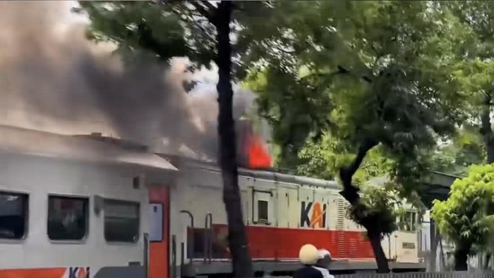 Lokomotif KA keluarkan api saat melintas di Jalan a Yani Surabaya