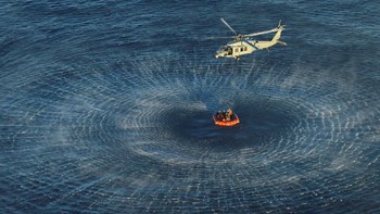 Awak pesawat Artemis II NASA diangkat ke dalam helikopter MH-60 Angkatan Laut AS dari perahu penyelamat. Foto: NASA