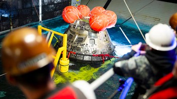 Pesawat ruang angkasa Orion milik NASA terlihat saat tim Pendaratan dan Pemulihan NASA, bersama dengan personel Angkatan Laut AS, berupaya memulihkan pesawat ruang angkasa tersebut ke dek lambung kapal USS John P. Murtha. Foto: NASA