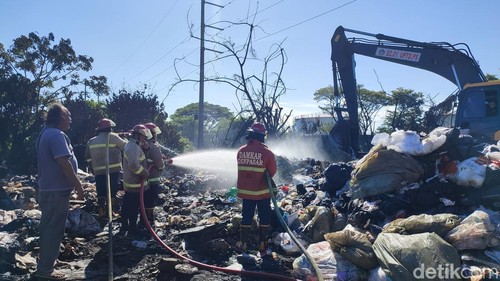 Petugas Damkar melakukan pendinginan usai kebakaran yang terjadi di gudang sampah dekat TPST Tahura I Ngurah Rai, Suwung, Denpasar. Selasa (14/4/2026).