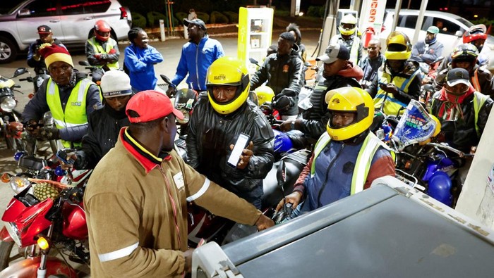 A motorcycle taxi rider gestures to the camera as he calls for more fuel to be readily available while waiting to refuel his motorcycle at a TotalEnergies petrol station ahead of an announced fuel price hike, as fuel costs rise amid global disruptions caused by the Iran war, in Nairobi, Kenya April 14, 2026. REUTERS/Thomas Mukoya