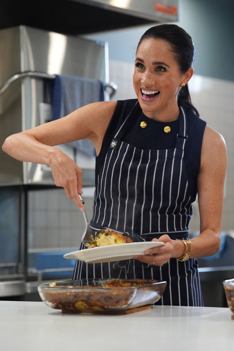 Meghan, the Duchess of Sussex serves lunch to a resident during a visit to McAuley Community Services for Women, a women's homeless and family violence shelter in Footscray, Melbourne, Australia, April 14, 2026.    Jonathan Brady/Pool via REUTERS