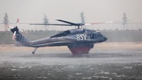 Helikopter dikerahkan untuk mengangkut air dan menjatuhkan air ke titik api sebagai bagian dari upaya pemadaman dari udara. Foto: REUTERS/Octavio Jones