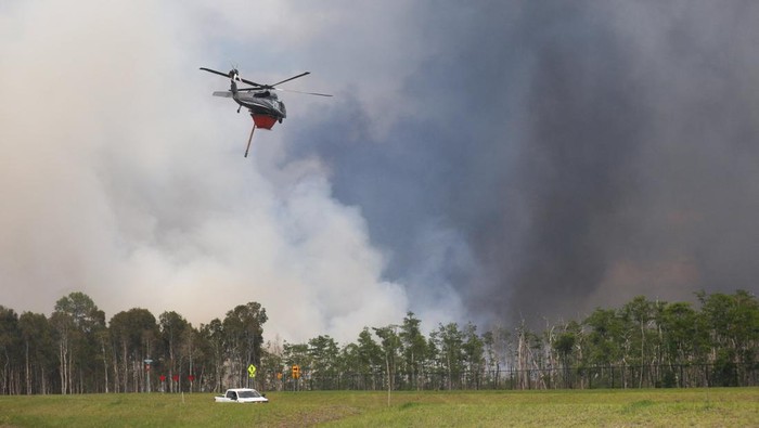 A helicopter flies as first responders with the Florida Fish and Wildlife Conservation Commission, Collier County Sheriff’s Office, and the U.S. Forest Service work to contain a brush fire at Picayune Strand State Forest in Naples, Florida, U.S., April 14, 2026. REUTERS/Octavio Jones